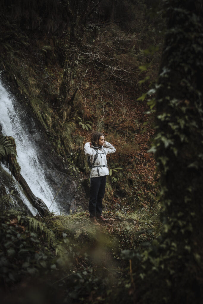 Photo d'une femme portant une veste Salomon sous une cascade